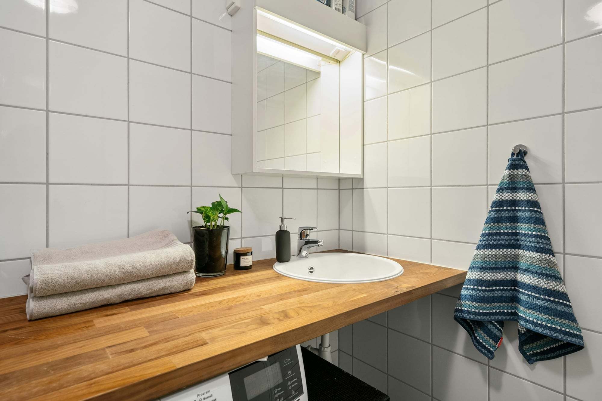 Salle de bain claire avec étagère en bois