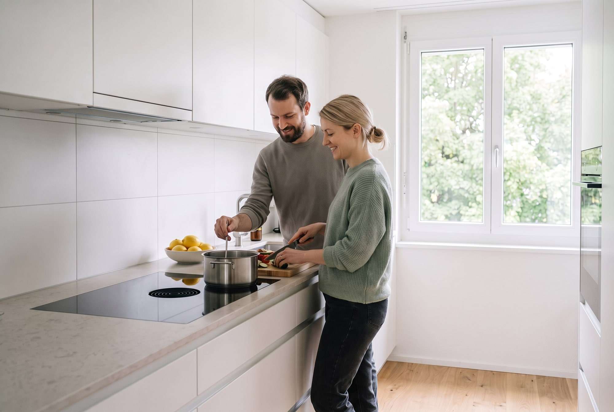 Couple cuisinant ensemble dans une cuisine lumineuse